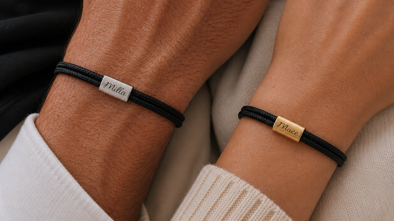 Sorte armbånd i nylon med graverede navne på stålplade